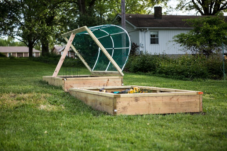 Two raised beds for gardening in the center of a grass lawn.