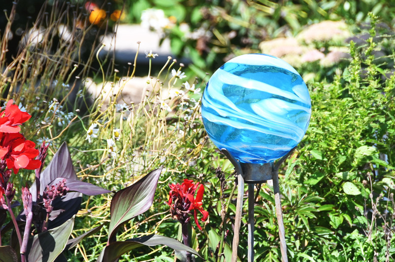 A swirly blue gazing ball positioned atop a decorative piece