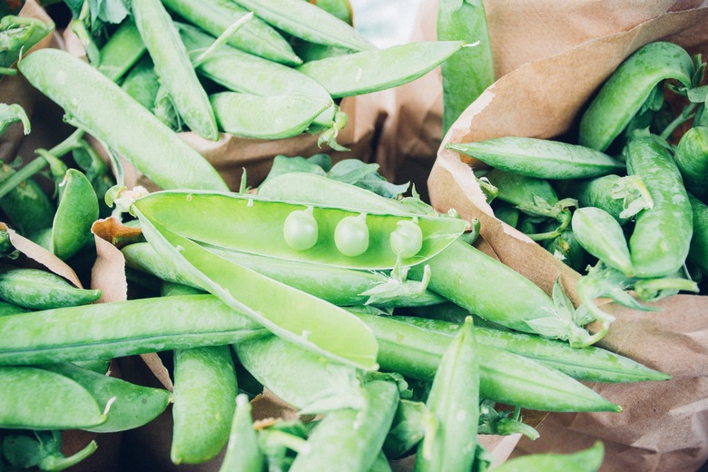Brown paper bags full of freshly harvested pea pods.