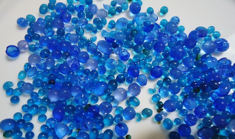 A bunch of blue silica gel on a white surface.