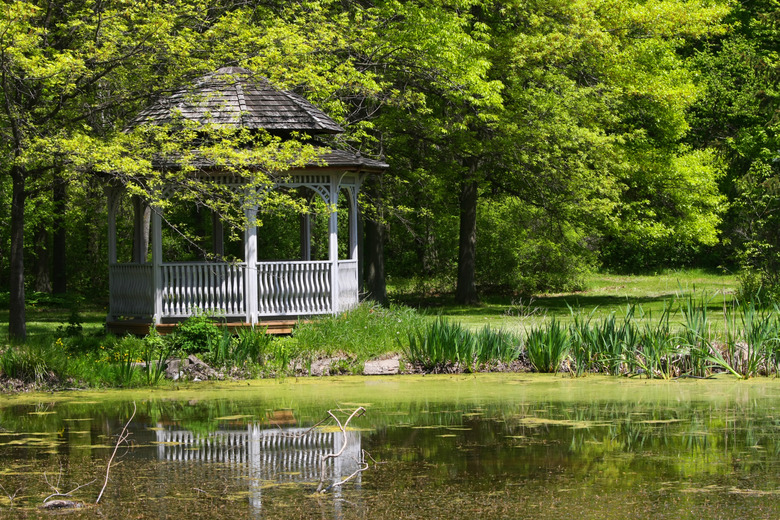 Grass surrounding a gazebo and water at a park