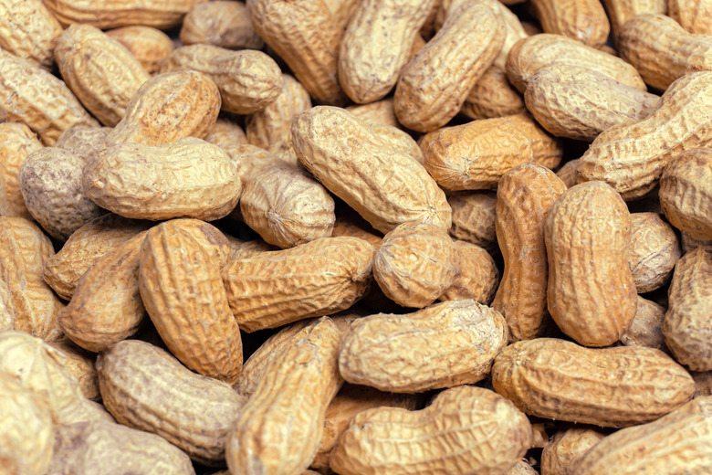 A close-up of a heap of unshelled peanuts.