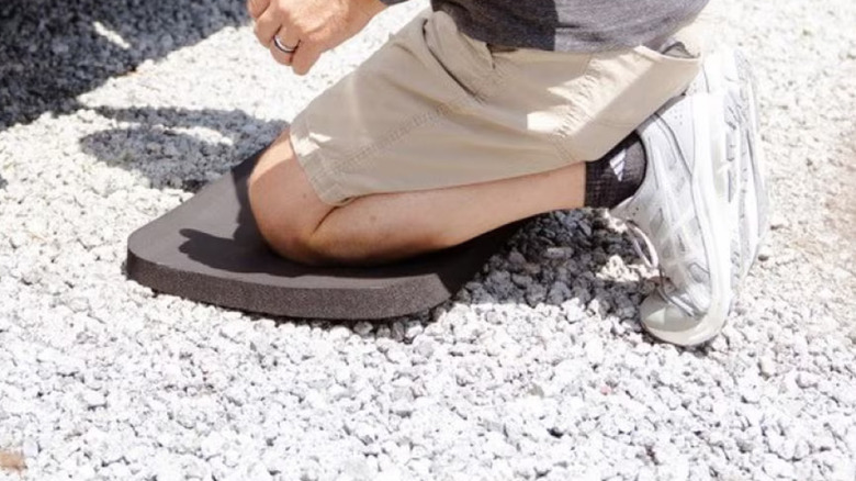 A man's knees on the Hyper Tough kneeling pad on gravel