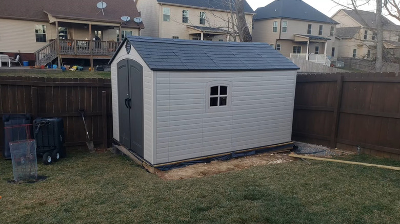 The Lifetime resin shed sits in a fenced in backyard.