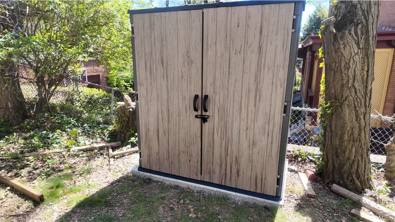 The Suncast shed from Costco stands in a yard.