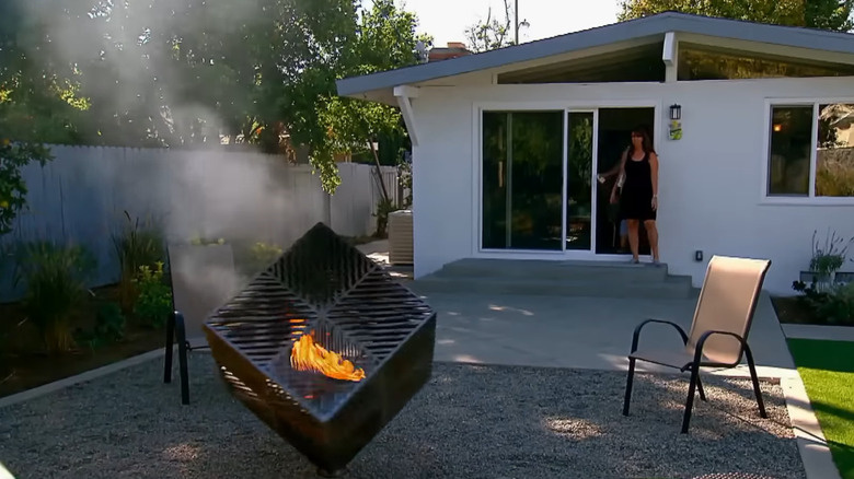 A rotating fire pit creates a unique gathering area in a backyard.