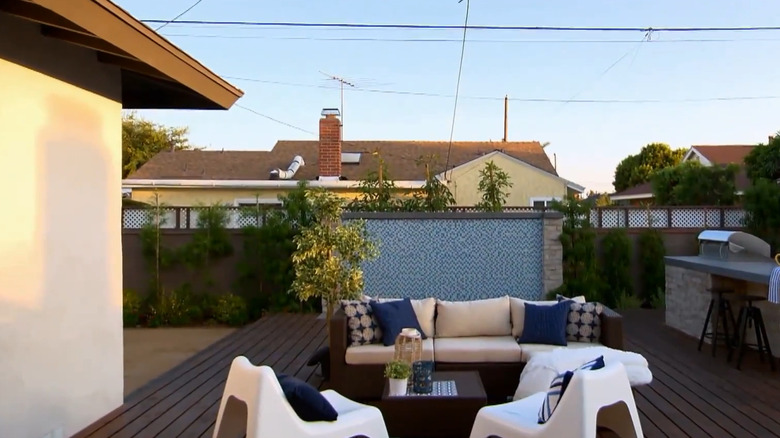 A  patio is complete with a grill, bar, and water feature.