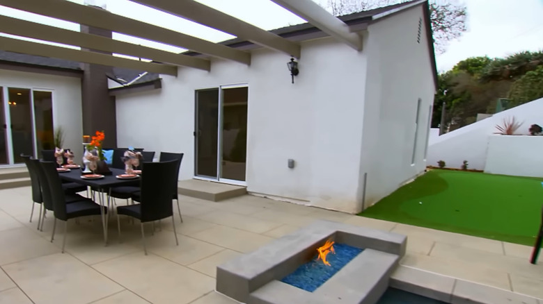 A putting green, spa, and fire pit create a fun backyard with plenty of entertainment