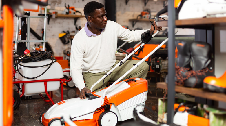 A man looks to buy a push lawn mower.