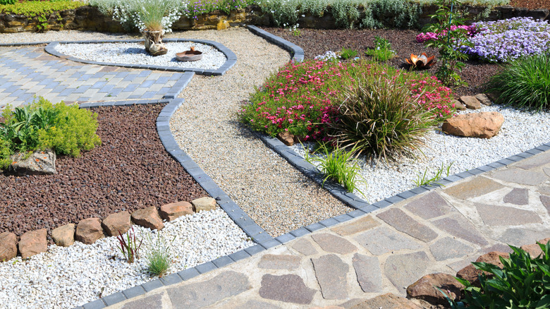 A garden with gravel, carefully planted plants, and stone paths.