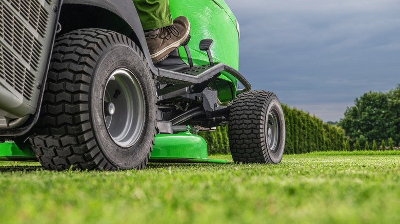 Close up view of the wheels of a riding lawn mower.
