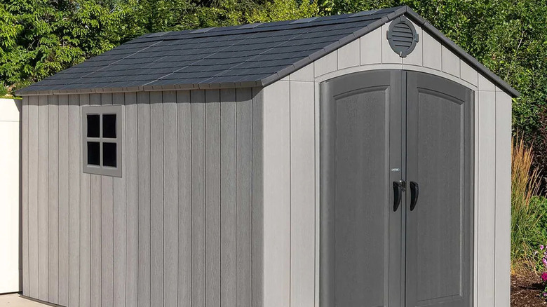 Gray resin shed against a green leafy background
