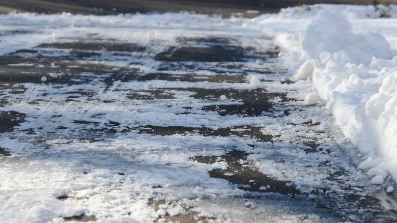 A shoveled driveway with snow piled on the side