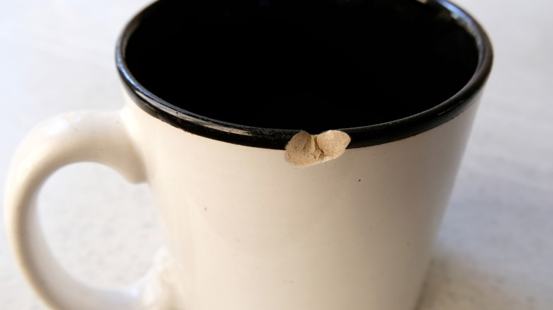 up-close shot of a white mug with a chipped black rim