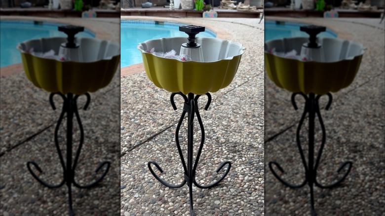 A colorful Bundt pan has been attached to a base to create a cute bird bath.