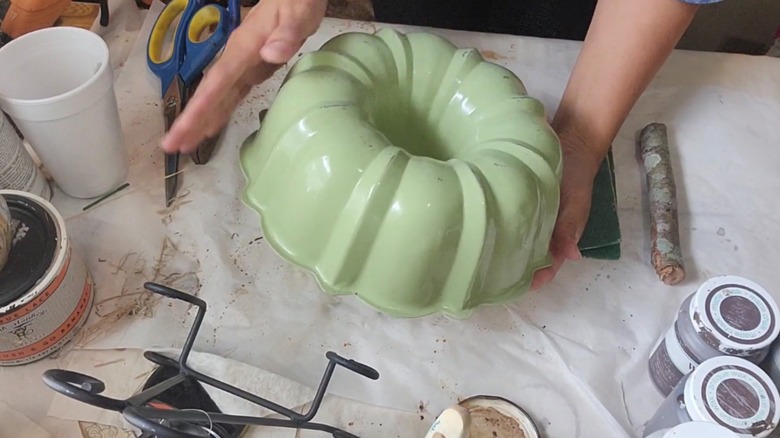 A woman paints a Bundt pan.
