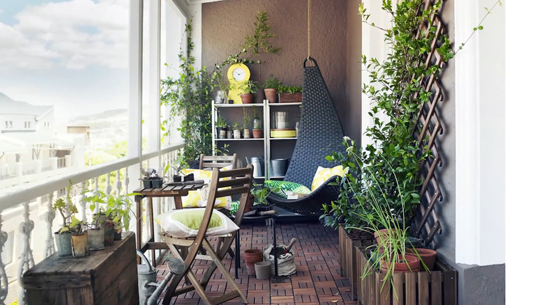 A balcony garden has a small Askholmen table and 2 chairs.