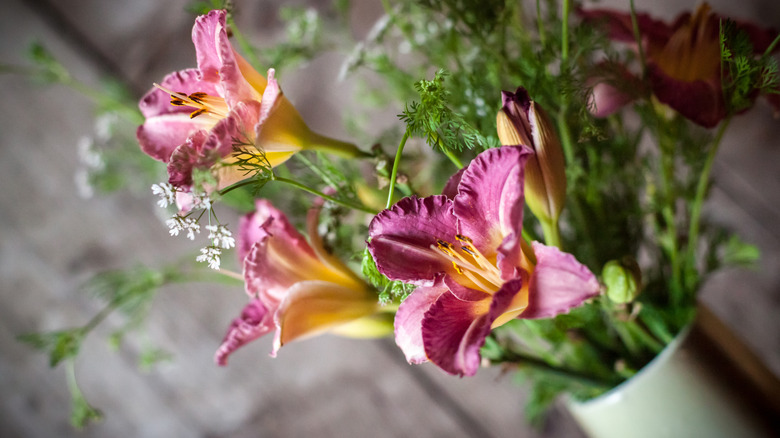 Pink daylilies arranged in a vase.