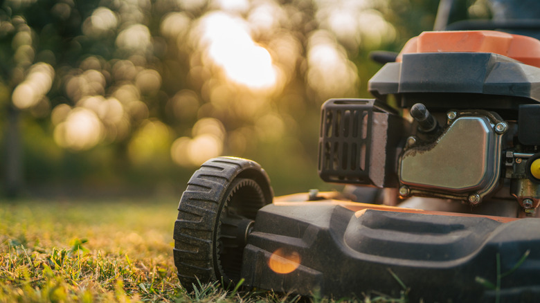 A lawn mower is shown in close up on the grass.