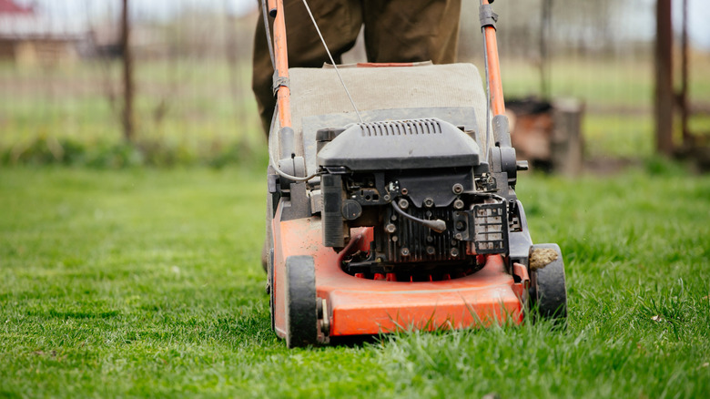 A person mows a lawn.