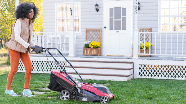 Woman mows her lawn.