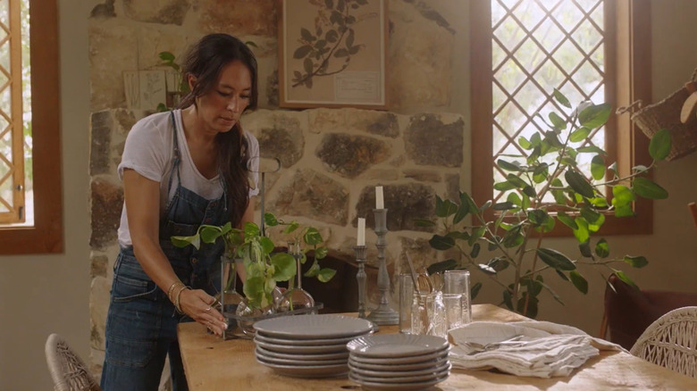 Joanna Gaines sets a vining houseplant on a table.