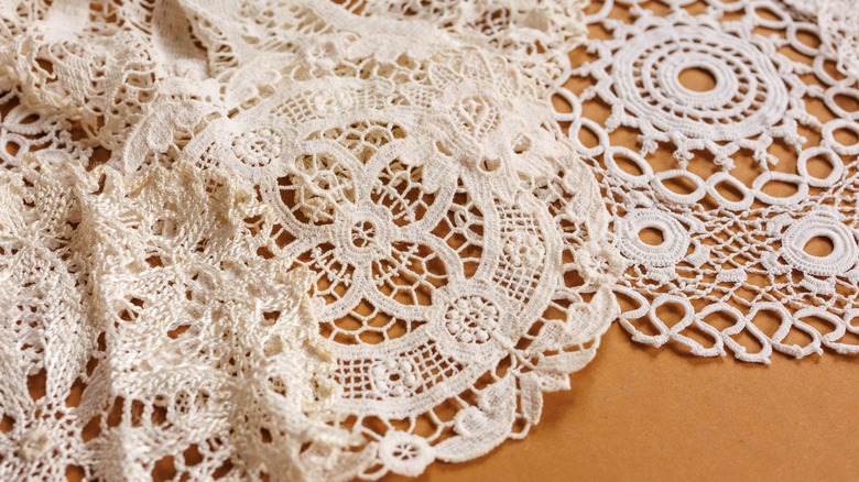 Doilies spread out on a wooden table.