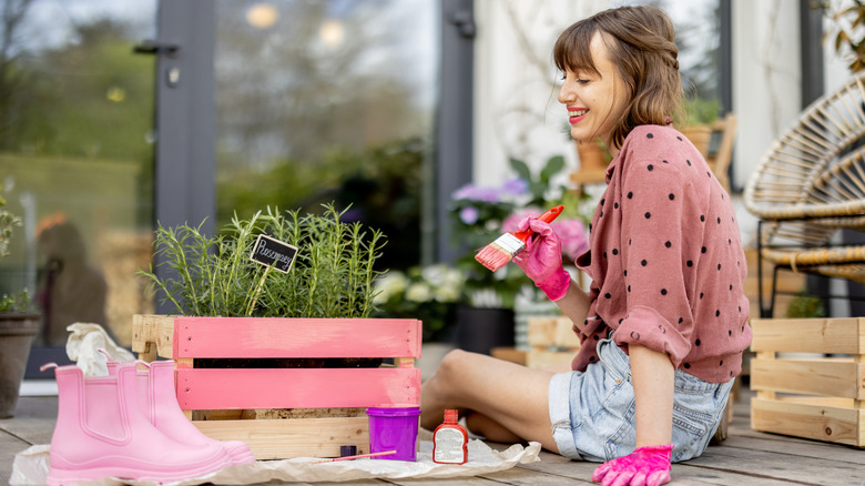 person applying paint to soup can for DIY