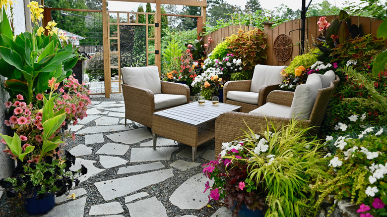 A patio is covered in planters of flowers.