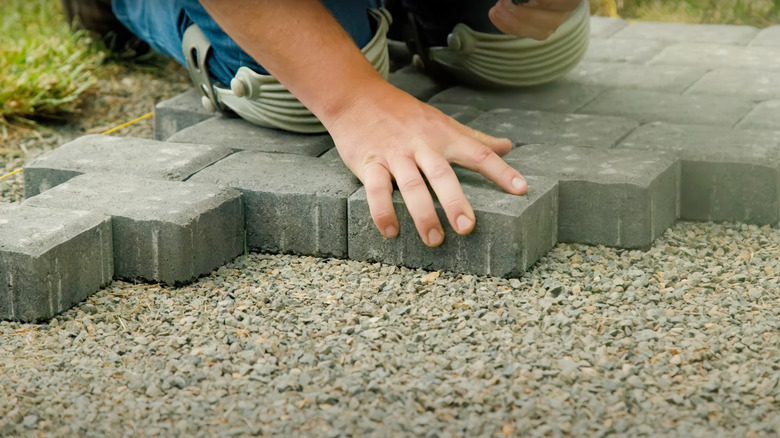 Concrete patio pavers are being placed.