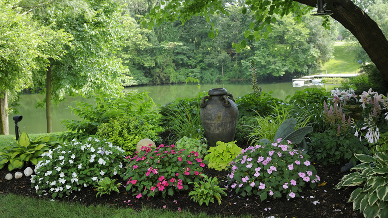 A shade garden thrives with colorful flowers.