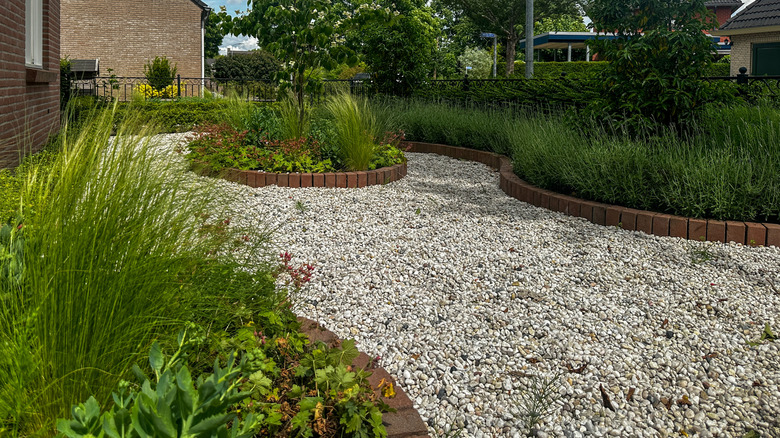 Gravel fills in a walking area with brick garden beds.