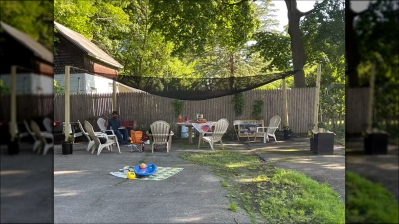 Man sits under a DIY shade pergola.
