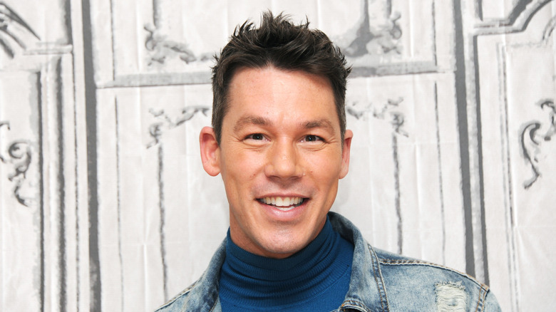 David Bromstad smiles in front of a white background.
