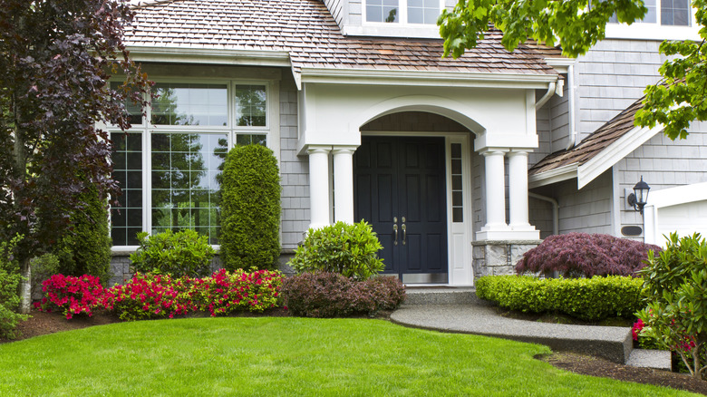 A front yard garden is filled with colorful blooms.