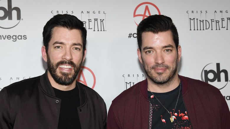 The Property Brothers stand on the read carpet.