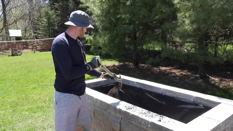 Mike Holmes Jr. fills a stone garden planter.