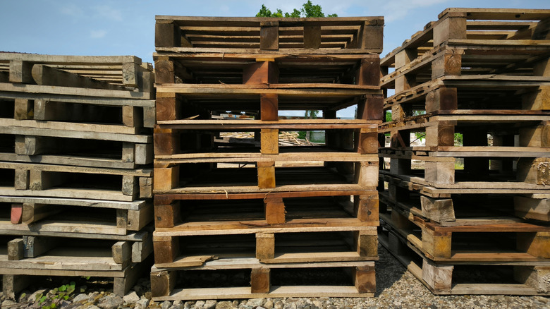 A stack of pallets are in a yard.