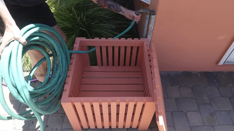 Garden hose box made to hide garden hose clutter.