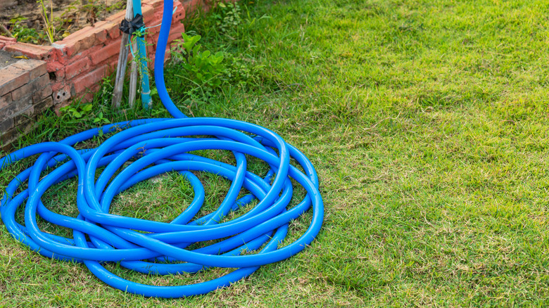 Get Rid Of Garden Hose Clutter With A Stylish DIY That Tucks It Out Of Sight