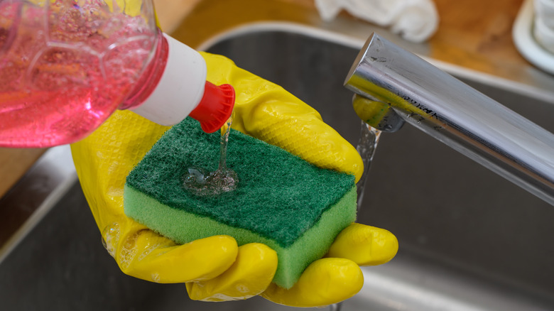 Dishwashing liquid is being suspended on a sponge